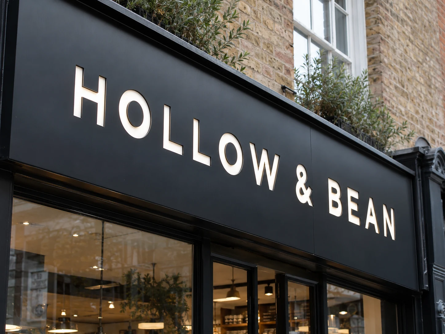 Lion Sign — CNC-routed black aluminium composite café signage with white acrylic inset letters.