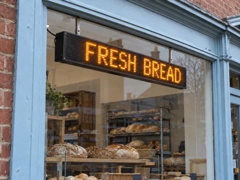 Lion Sign — Amber LED scrolling sign for bakery promotions and store messages.