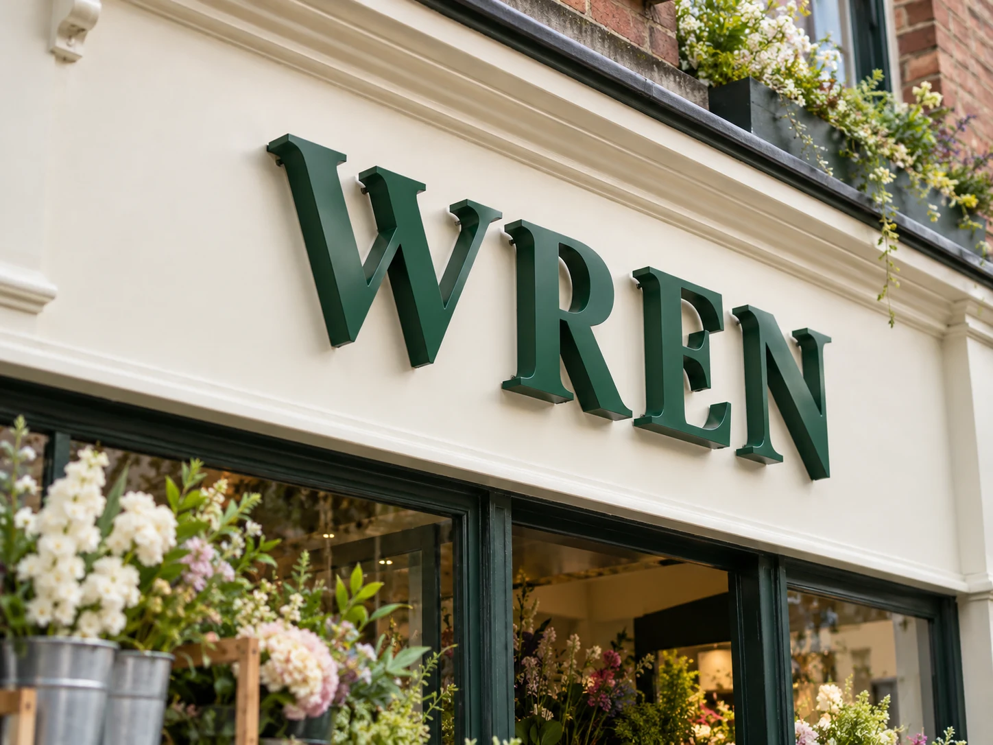 Lion Sign — Forest-green powder-coated 3D metal letters for boutique and florist branding.
